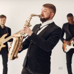Banda de jazz toca ao vivo em um palco, com músicos executando diferentes instrumentos.