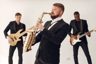 Banda de jazz toca ao vivo em um palco, com músicos executando diferentes instrumentos.