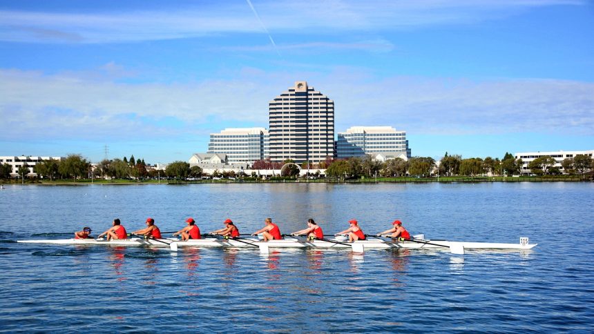 Equipe de remo com oito atletas competindo em uma regata na água.